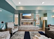 Thumbnail 7 of 102 - A living room with a fireplace and a painting on the wall.
