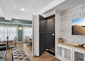 Thumbnail 9 of 102 - A modern living room with a black door and a large painting on the wall.