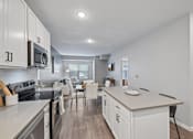 Thumbnail 92 of 102 - A modern kitchen with white cabinets and stainless steel appliances.