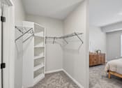 Thumbnail 95 of 102 - A bedroom with a bed, dresser, and a staircase.