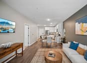 Thumbnail 91 of 102 - A living room with a white couch and a wooden coffee table.