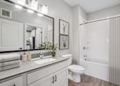 Thumbnail 61 of 91 - A bathroom with a white toilet, sink, and bathtub.
