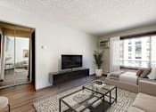 Thumbnail 17 of 20 - A modern living room with a flat screen TV and a glass coffee table.