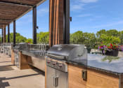 Thumbnail 84 of 105 - an outdoor kitchen with stainless steel appliances and a bar at The Gateway at West Lake Quarter in Minneapolis, MN
