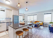 Thumbnail 3 of 91 - a kitchen and living room with white cabinets and a large island with stools at The Morrison, Rosemount Minnesota