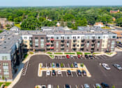Thumbnail 59 of 91 - an aerial view of a large apartment complex with a parking lot and trees in the background at The Morrison, Rosemount Minnesota