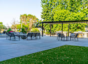 Thumbnail 71 of 91 - a patio with a pergola and tables and chairs at The Morrison, Rosemount Minnesota