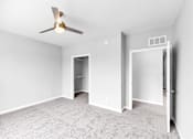 Thumbnail 48 of 97 - A room with a ceiling fan and carpeted floor.