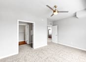 Thumbnail 45 of 97 - A room with a ceiling fan and carpeted floor.