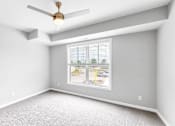 Thumbnail 43 of 97 - A room with a ceiling fan and a window showing a street view.