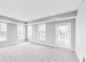 Thumbnail 34 of 97 - A spacious room with grey carpeting and white walls.