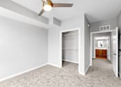 Thumbnail 28 of 97 - A room with a ceiling fan and carpeted floor.