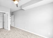 Thumbnail 22 of 97 - A room with a ceiling fan and a doorway leading to another room.