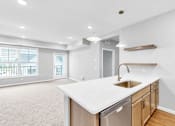 Thumbnail 31 of 97 - A kitchen with a white countertop and wooden cabinets.