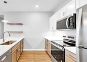 Thumbnail 23 of 97 - A modern kitchen with stainless steel appliances and wooden cabinets.