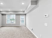 Thumbnail 15 of 97 - A spacious room with a carpeted floor and a window with blinds.