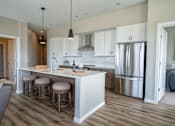 Thumbnail 9 of 45 - A kitchen with a white counter and stools.