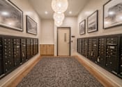Thumbnail 6 of 45 - A hallway with a carpeted floor, a chandelier, and a door at the end.