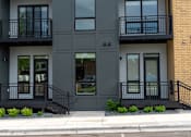 Thumbnail 43 of 45 - A modern two-story building with black railings and windows.