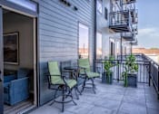 Thumbnail 42 of 45 - A balcony with a table and chairs.