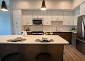 Thumbnail 33 of 45 - A kitchen with a white countertop and stainless steel appliances.