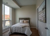 Thumbnail 38 of 45 - A bedroom with a large bed and a window overlooking a city.
