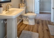 Thumbnail 37 of 45 - A white toilet sits in a bathroom next to a white sink.