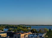 Thumbnail 28 of 45 - A cityscape with buildings and a body of water in the distance.