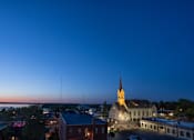 Thumbnail 30 of 45 - A church with a tall steeple stands out against the evening sky.