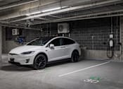 Thumbnail 56 of 69 - A white Tesla car is parked in a charging station.