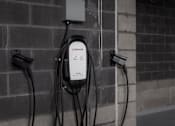 Thumbnail 55 of 69 - An electric vehicle charging station with a white Enphase charger plugged into a brick wall.