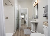 Thumbnail 25 of 69 - A white bathroom with a white sink and a white toilet.