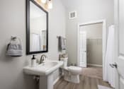 Thumbnail 26 of 69 - A white bathroom with a sink, toilet, and mirror.