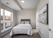 Thumbnail 22 of 69 - A bedroom with a large bed and a painting on the wall.