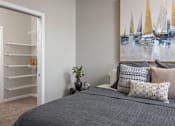 Thumbnail 19 of 69 - A bedroom with a grey bedspread and a painting of sailboats on the wall.