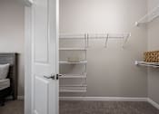 Thumbnail 24 of 69 - A white closet with shelves and a door.