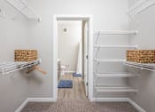 Thumbnail 20 of 69 - A hallway with a doorway leading to a bathroom and a carpet on the floor.