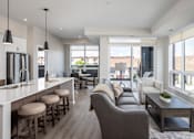 Thumbnail 13 of 69 - A modern living room with a bar area and a view of the outdoors.
