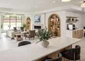 Thumbnail 33 of 69 - A modern living room with a large white table and brown chairs.