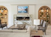 Thumbnail 44 of 69 - A living room with a fireplace and a painting above it.