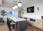Thumbnail 50 of 69 - A modern kitchen with a white island and wooden cabinets.