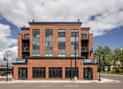 Thumbnail 66 of 69 - A red brick building with a black awning that says "LEASING" on it.