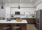 Thumbnail 3 of 69 - A modern kitchen with white cabinets and a stainless steel refrigerator.