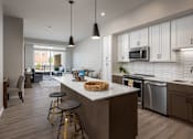 Thumbnail 2 of 69 - A kitchen with a white countertop and a bar stool.