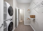 Thumbnail 8 of 69 - A laundry room with a washer and dryer on the left and a walk-in closet on the right.