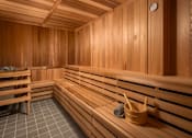 Thumbnail 39 of 69 - A wooden sauna with benches and a bucket of stones.