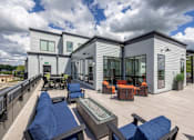 Thumbnail 52 of 69 - A modern house with a deck and patio furniture.