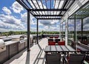 Thumbnail 53 of 69 - A patio with a table and chairs is covered by a roof.