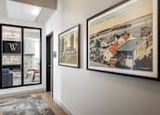 Thumbnail 46 of 69 - A hallway with a rug and two framed pictures on the wall.