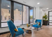 Thumbnail 103 of 105 - a living room with two blue chairs and a large window